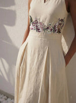 Load image into Gallery viewer, Close-up of hand-embroidered floral cross-stitch detail on Celia Linen Midi cream dress – artisanal embroidery on premium linen