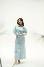 Load image into Gallery viewer, Woman wearing light blue midi dress with corsage detail standing in studio with soft white background.