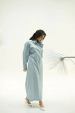 Load image into Gallery viewer, Side profile of model wearing Alora blue corsage dress with subtle pleats against light background.
