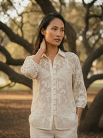 Load image into Gallery viewer, Woman posing in ivory crochet summer lace shirt, side angle view, breathable floral lace casual women’s shirt.