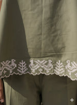 Load image into Gallery viewer, Close-up of white embroidered hem on olive green strapless co-ord set – handcrafted summer fashion detail