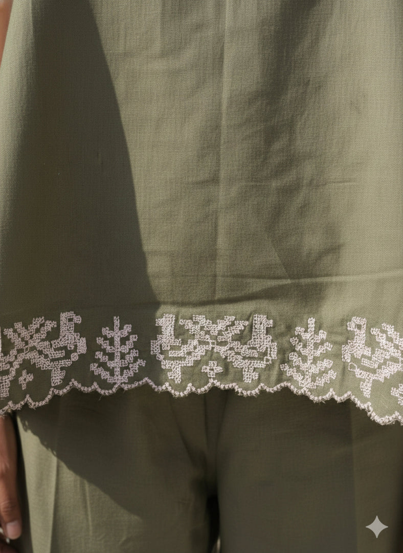 Close-up of white embroidered hem on olive green strapless co-ord set – handcrafted summer fashion detail
