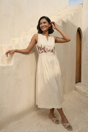 Model wearing Celia Linen Midi cream dress with V-notch neckline and pleated skirt – floral embroidered dress for brunch and resort wear