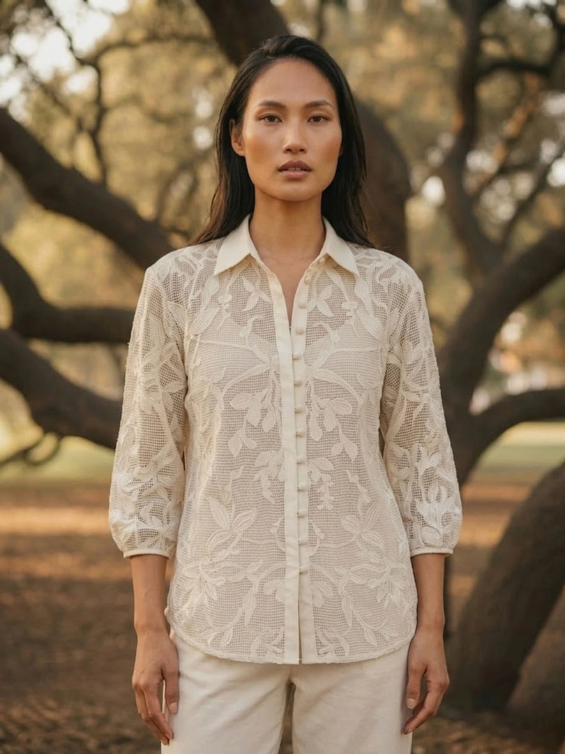 Woman wearing ivory openwork lace shirt with matching pants, front view, elegant summer co-ord lace blouse.