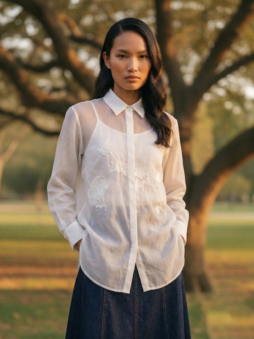Lightweight white resort blouse with navy pants, full-length summer fashion look for women.
