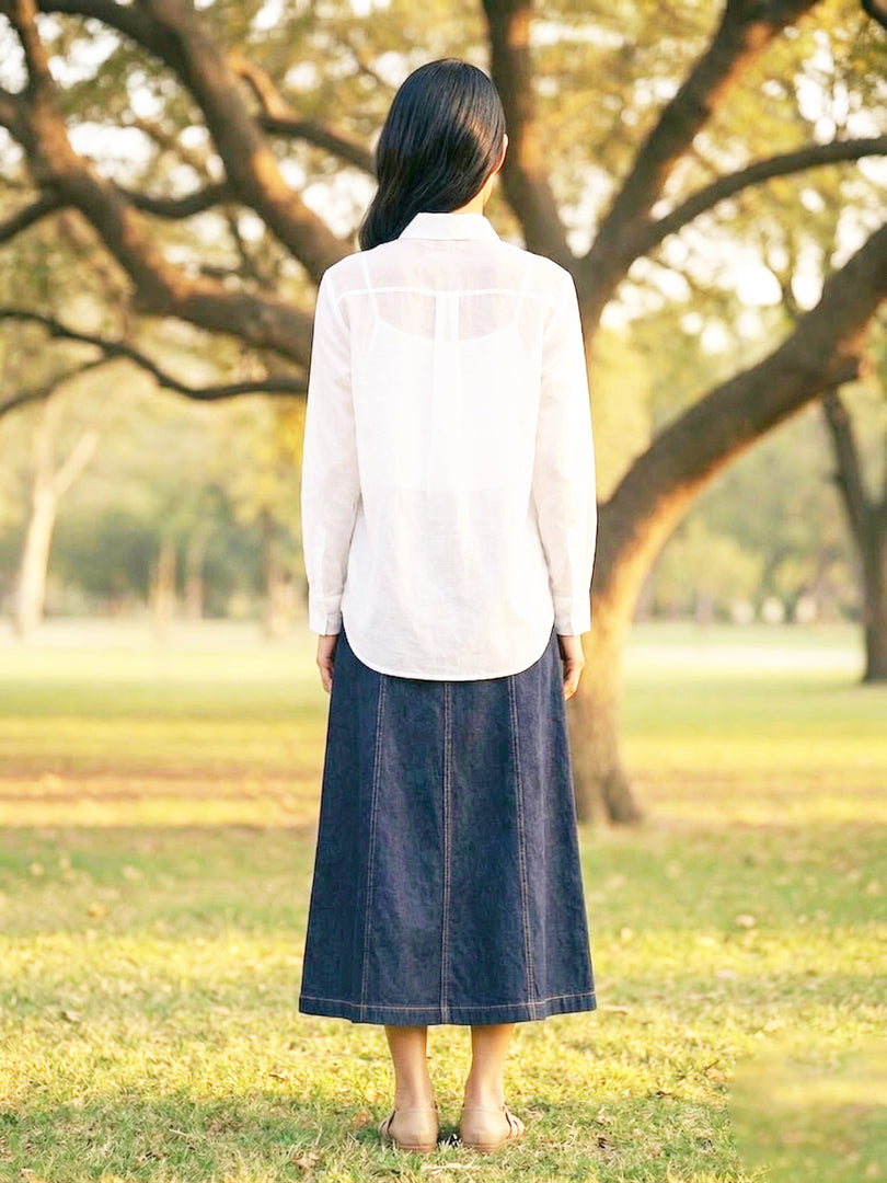 Stylish women’s white workwear shirt with dark blue trousers, versatile resort and casual outfit look.