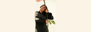 Person holding a large flower against a white background